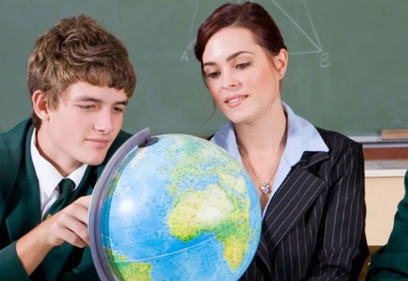 Учитель объясняет географию по глобусу